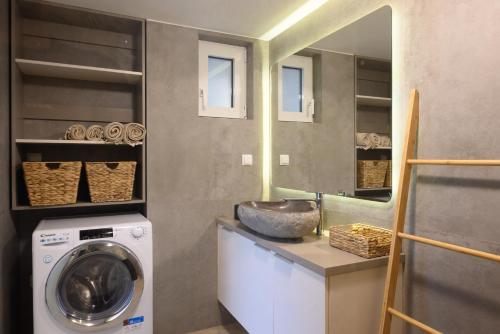 a laundry room with a sink and a washing machine at Cestrum Suites in Agios Nikolaos
