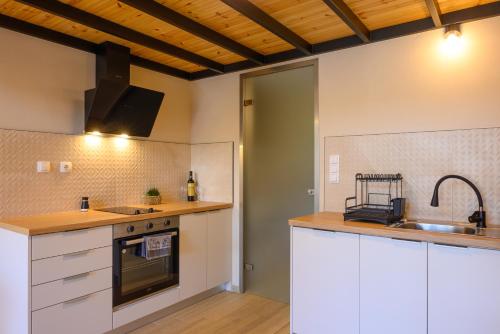 a kitchen with white cabinets and a sink at Cestrum Suites in Agios Nikolaos