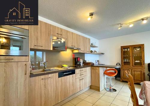 une cuisine avec des armoires en bois et un évier dans l'établissement Appartement T3 - Sallanches, à Sallanches