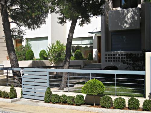 a fence in front of a house at Villa Serenity in Porto Rafti