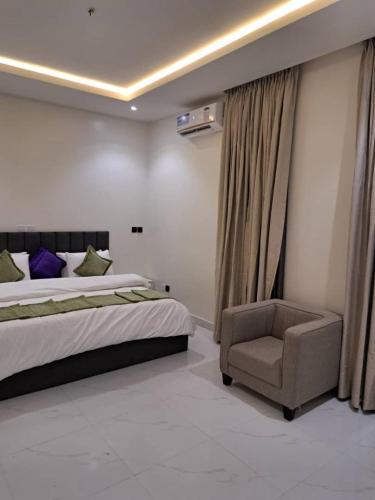 a bedroom with a bed and a chair at Luxury Apartment & Homes in Mama