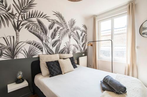 une chambre avec un lit avec un papier peint tropical dans l'établissement Immeuble spacieux - hyper centre - 15 couchages, à Reims