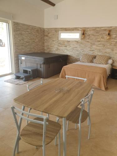 une table et des chaises dans une chambre avec un lit dans l'établissement La Parenthèse, à Tavernes