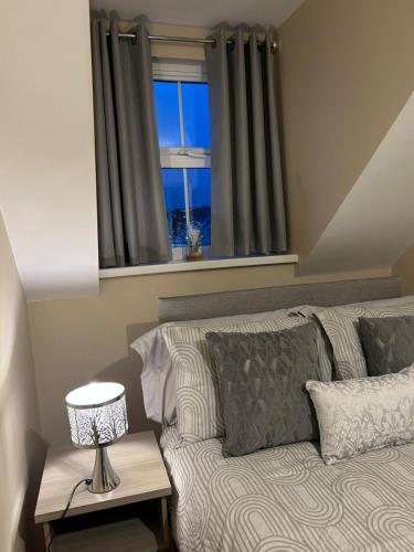 a bedroom with a bed with a window and a lamp at Port Panorama in Portstewart