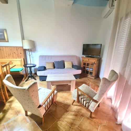 a living room with a couch and chairs and a table at CASA CAL METGE in Benissanet