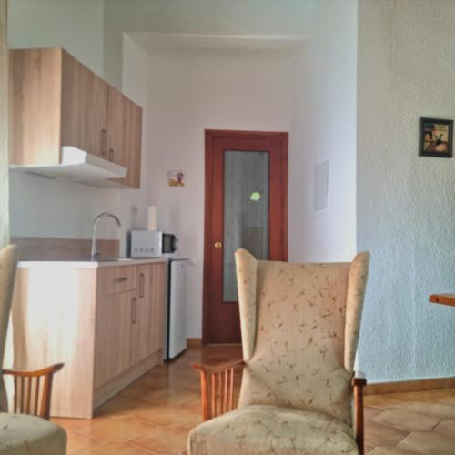 a living room with a chair and a kitchen at CASA CAL METGE in Benissanet