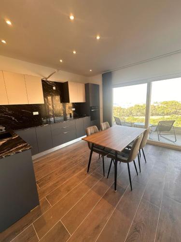 a kitchen and dining room with a wooden table and chairs at One Bedroom in New Apt Mellieha- Blue Room 2 in Mellieħa