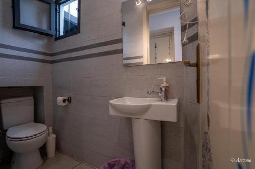 a bathroom with a sink and a toilet and a mirror at Hotel Miramonte in Chefchaouene