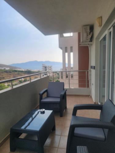 a balcony with two chairs and a couch and a table at 2F Saranda Apartment 3 in Sarandë