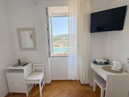 a white room with a desk and a window at Studio Appartment & Rooms Old Town in Rab