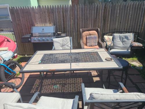 a picnic table with chairs and a grill in a backyard at ARMANI MANOR Rustic UNIT 2 in Wildwood