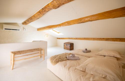two beds in a attic bedroom with wooden beams at CASA ANANTA Appartements bien-être aux portes du Verdon Refuge slow Life et sensoriel jusqu à 12 pers in La Garde