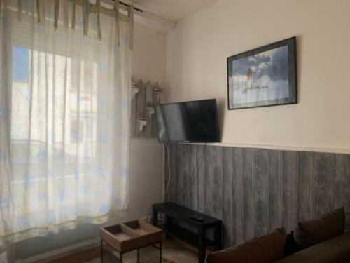 Il comprend un salon doté d'une télévision et d'une fenêtre. dans l'établissement Votre pied à terre à proximité des dunes, à Berck-sur-Mer