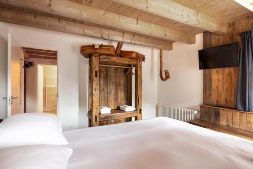 a bedroom with a bed and a flat screen tv at Studio Ebi Vacation - Alleghe - Monte Civetta in Alleghe