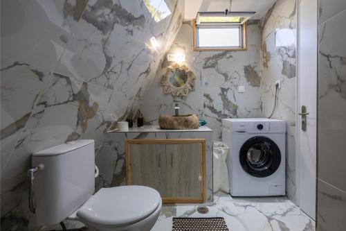 a bathroom with a toilet and a washing machine at Olive Frame in Zakynthos Town