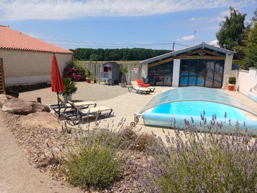 - une piscine dans une cour avec des chaises et un parasol dans l'établissement Gîte de charme, à Saint-Martin-sous-Mouzeuil