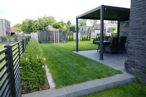 a patio with a fence and a table in a yard at Ferienhaus am Lankower See in Schwerin