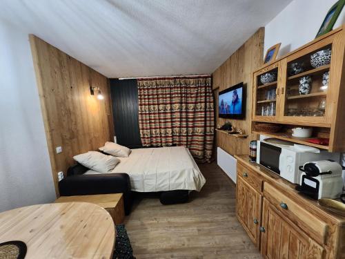 une petite chambre avec un lit et une télévision dans l'établissement L'écrin de la Rosière, Résidence le Vanoise au pied des pistes, à Montvalezan