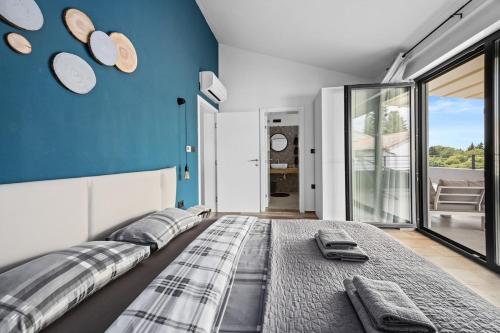 a bedroom with a large bed and a blue wall at Villa Kali by IstriaLux in Krnica