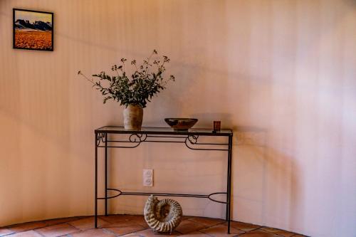 une table avec un vase et une plante sur elle dans l'établissement Ostal de la placette, à Padern