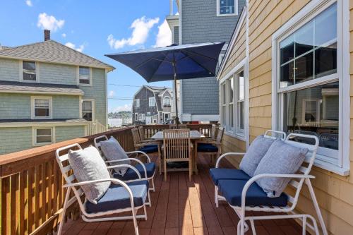 a deck with chairs and a table and an umbrella at Life of Reilly - Scituate in Scituate