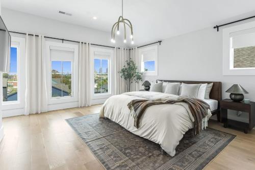 a white bedroom with a large bed and windows at The Blackbrick Manor in Atlanta