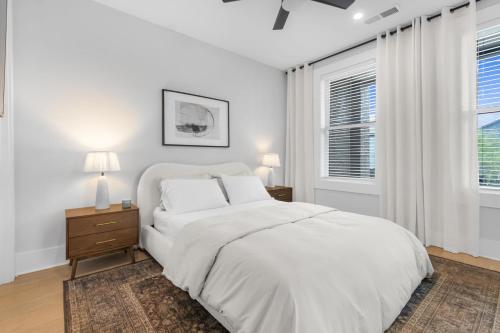 a white bedroom with a bed and two windows at The Blackbrick Manor in Atlanta