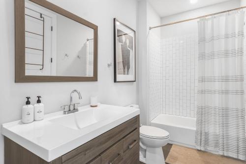 a white bathroom with a sink and a toilet at The Blackbrick Manor in Atlanta