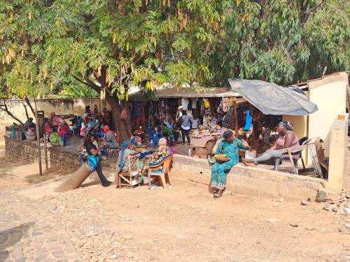 a group of people sitting in chairs in a market at Casa Djoko in Dakar