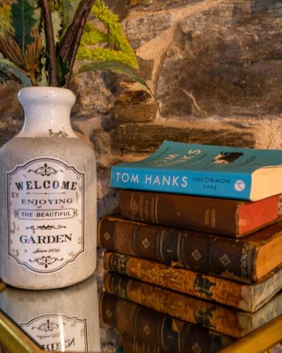 a stack of books next to a vase and a stack of books at Complejo Rural Lar de Vies in A Pontenova