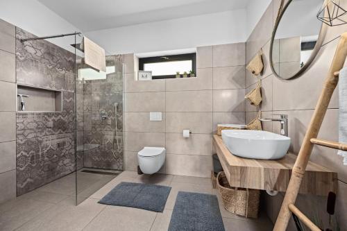 a bathroom with a sink and a toilet and a shower at Villa Kali by IstriaLux in Krnica