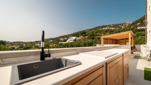 a kitchen with a sink and a view of a mountain at Villa Mianka Rab in Banjol