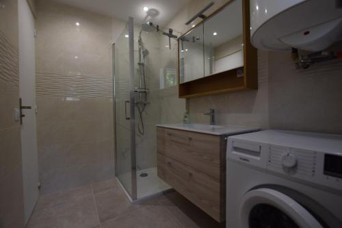 une salle de bain avec douche et lavabo et une machine à laver dans l'établissement SETTE B Locations T3 Bas Villa, à Cavalaire-sur-Mer