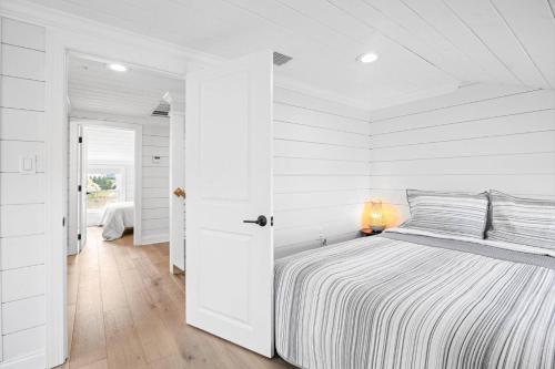 a white bedroom with a bed and a white wall at Stunning and Stilted - Scituate in Scituate