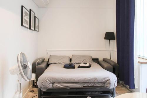 un lit dans une chambre avec un ventilateur et un lit dans l'établissement Nice Studio Near Eiffel Tower, à Paris