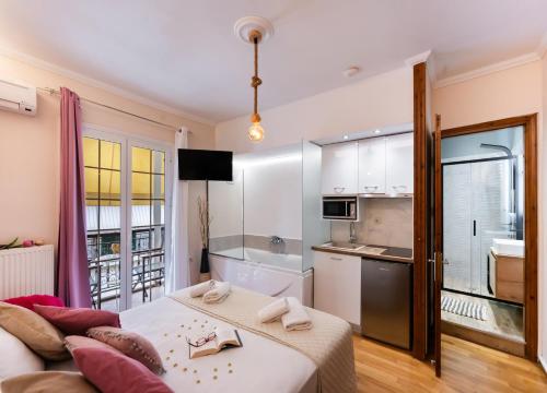 a small bedroom with a bed and a kitchen at LEFKAS CITY APARTMENTS & Suites in Lefkada Town