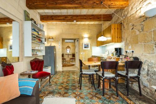 a kitchen and living room with a table and chairs at Cosy Haven, 96 Triq il-Karita', Victoria Gozo in Victoria