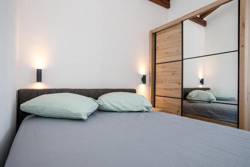 a bedroom with a large bed with two pillows at Gabriel Home in Rab
