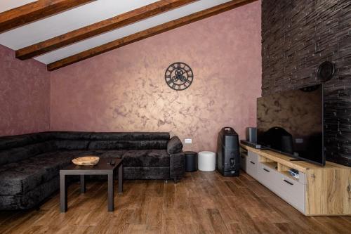 a living room with a couch and a tv at Gabriel Home in Rab