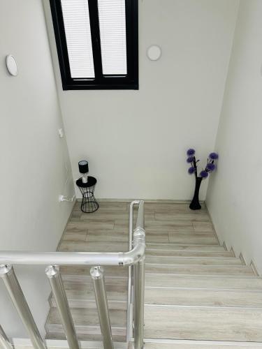a stairway with a white wall and a window at Lemongarden in Akcaabat