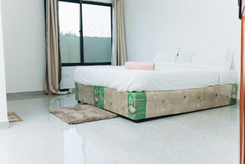 a bedroom with a bed with a wooden frame at Gotriips Apartments in Lusaka