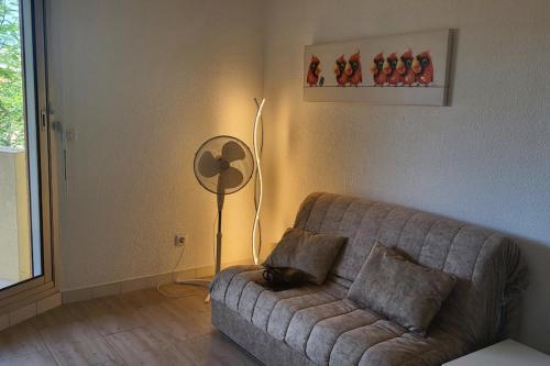 - un salon avec un canapé et un ventilateur de sol dans l'établissement 1 bedroom apartment with balcony near the beach, à Saint-Raphaël