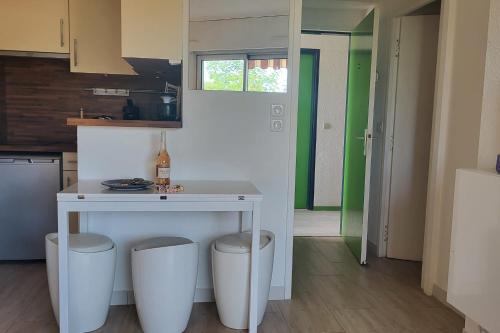 une cuisine avec une table et deux tabourets dans l'établissement 1 bedroom apartment with balcony near the beach, à Saint-Raphaël