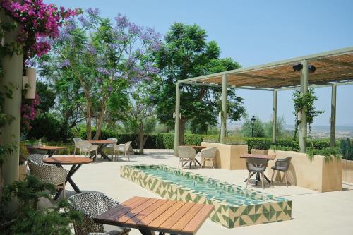 a patio with tables and chairs and a pool at Es Figueral Nou Hotel Rural & Spa - Adults Only - Over 12 in Montuiri