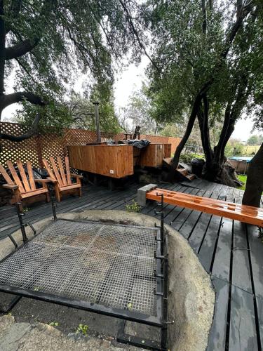 a patio with chairs and a table and a tree at Bosque in Antuco
