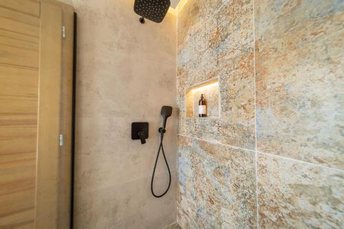 a bathroom with a shower with a phone on the wall at Villa Mianka Rab in Banjol