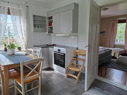 a kitchen and living room with a table and chairs at Privat leilighet på gård med badstue og nordlys in Narvik