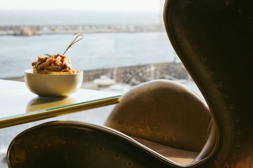 a bowl of food sitting on a table next to a window at Octant Ponta Delgada in Ponta Delgada