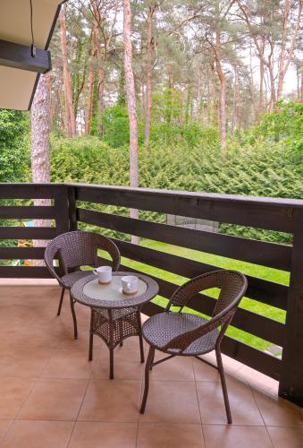 two chairs and a table on a porch with a table and chairs at Comfortable 4 bedroom villa outdoor wood-fired sauna Warsaw in Magdalenka