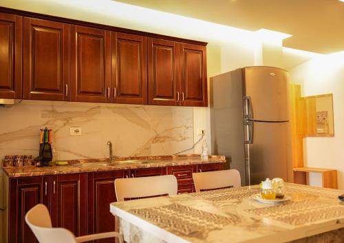 a kitchen with a table with chairs and a refrigerator at DelMar Apartments in Golem